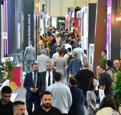 Ziyaretçiler kalabalık salondaki stantları ziyaret ediyor